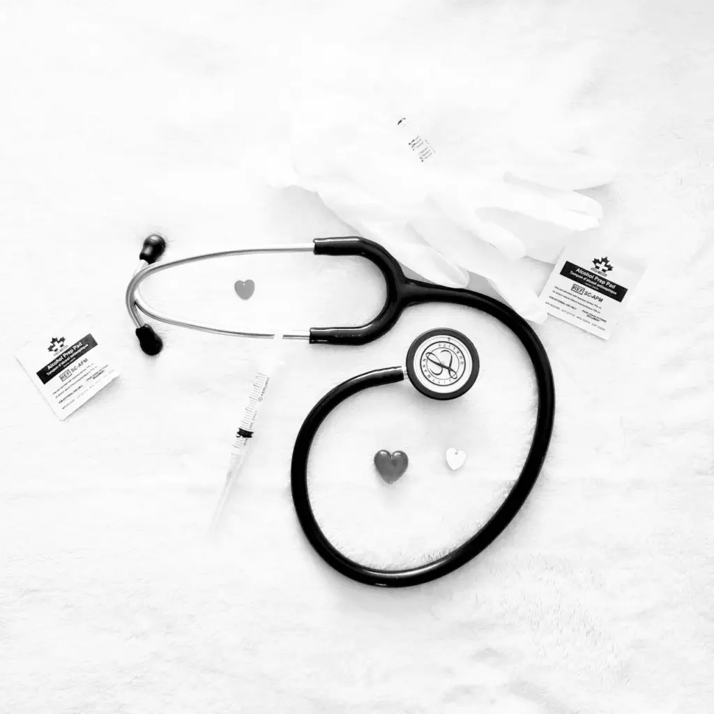 Stethoscope and medical items laid out on a white surface