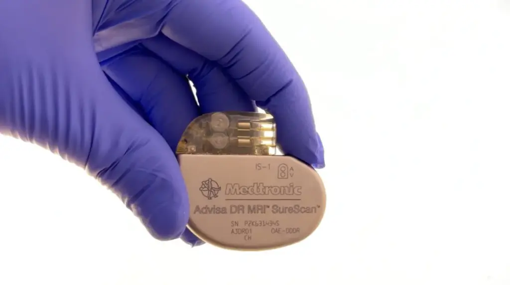 Gloved hand holding a pacemaker