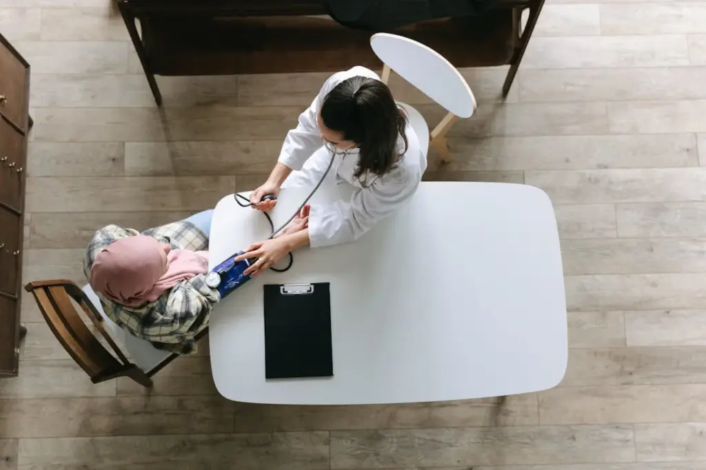 Clinician checking a patient's blood pressure at a table